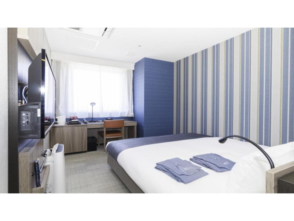 Cette chambre comprend un lit et un bureau. dans l'établissement La'gent Stay Hakodate Ekimae - Vacation STAY 75056v, à Hakodate