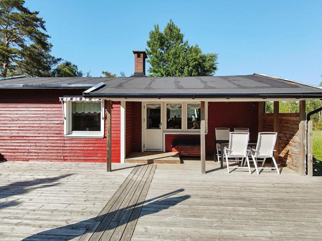 Casa roja con porche con sillas en el patio en Holiday home Brastad X, en Brastad