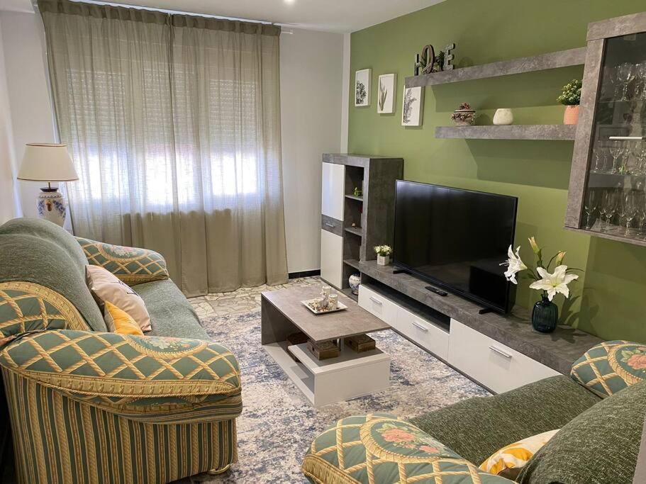 a living room with two couches and a flat screen tv at Casa de María in Muros