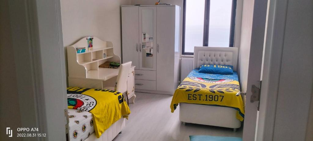 - une petite chambre avec 2 lits et une fenêtre dans l'établissement Güzel evim, à Cayeli