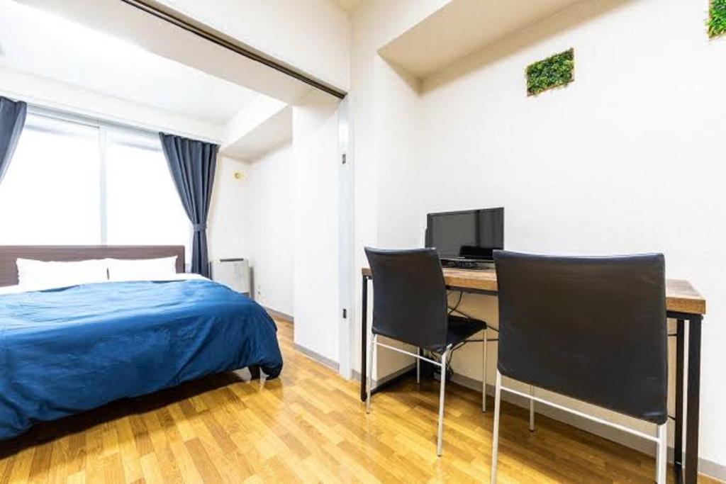 a bedroom with a bed and a desk with a computer at E-Horizon Kita 2 Jo Building - Vacation STAY 14740 in Sapporo