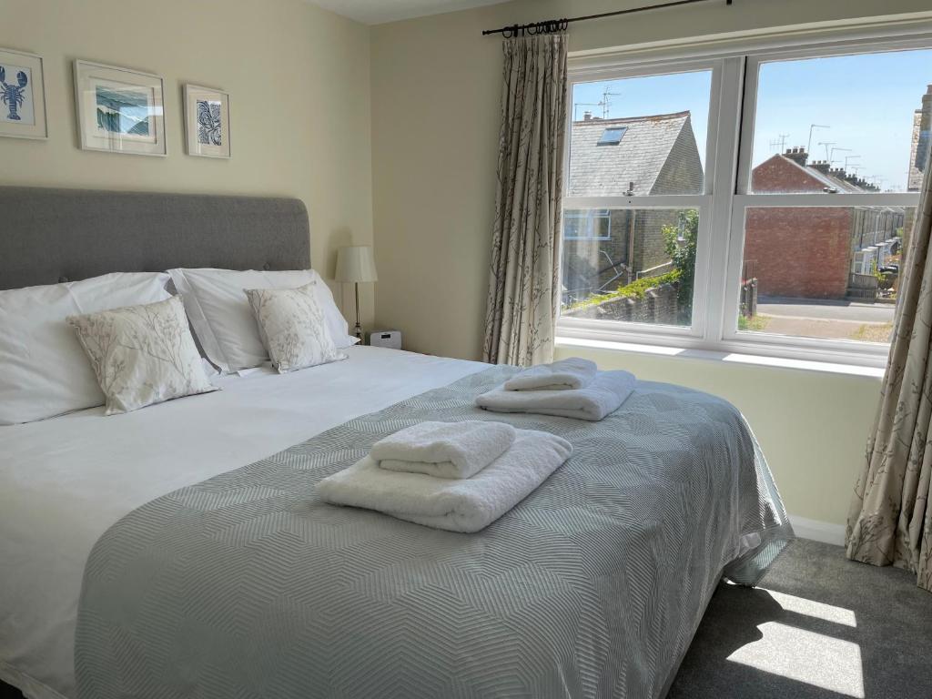 1 dormitorio con 1 cama con 2 toallas en Courtyard House, with parking and patio garden en Whitstable