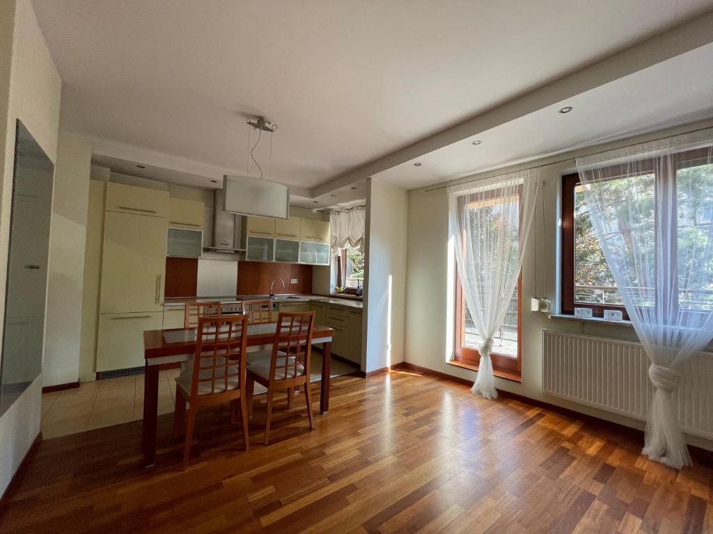 een keuken en eetkamer met een tafel en stoelen bij Apartament Deptakiem Nad Morze in Gdańsk
