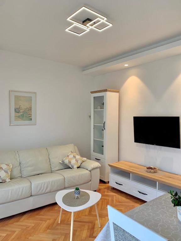 a living room with a couch and a flat screen tv at Talija Apartments in Bijela