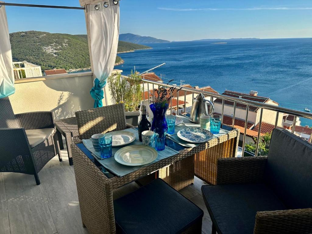 a table on a balcony with a view of the ocean at Tanis Ocean Loft in Martinšćica