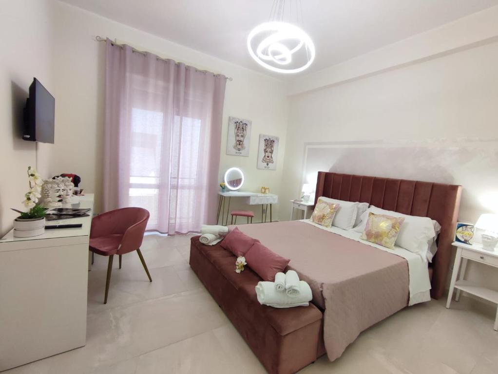 a bedroom with a bed and a desk and a chair at Siracusa Ortigia by Duomo in Syracuse