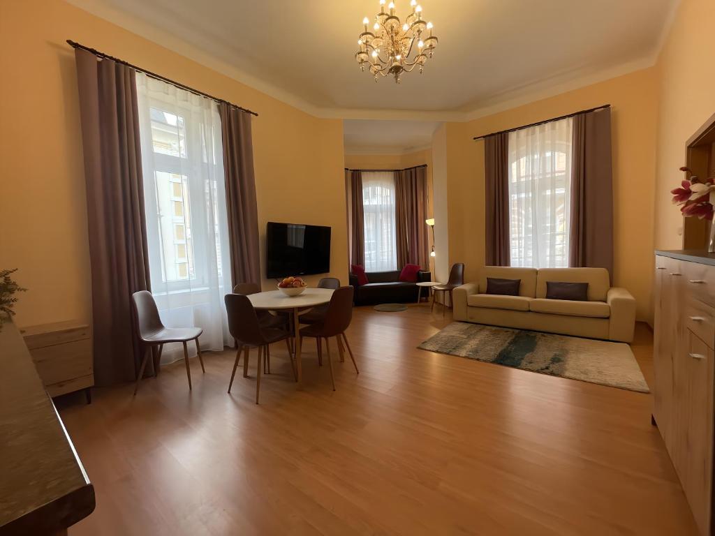 uma sala de estar com uma mesa e um sofá em Anzio apartments em Mariánské Lázně