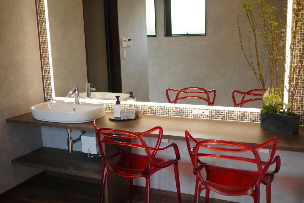 a bathroom with red chairs and a sink and a mirror at Marna family - Vacation STAY 69396v in Takaoka