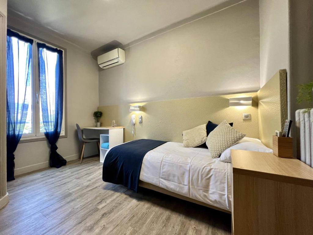 a hotel room with a bed and a desk at Hotel La Calanque in Mandelieu-La Napoule