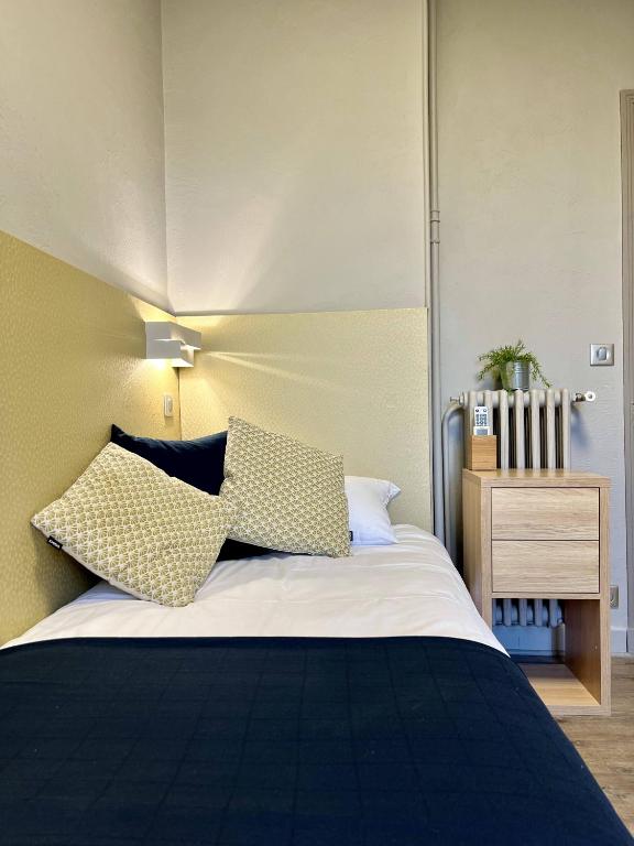 a bedroom with a bed with two pillows on it at Hotel La Calanque in Mandelieu-La Napoule
