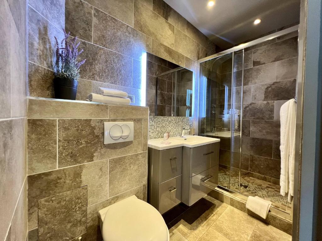 a bathroom with a toilet and a sink and a shower at Hotel La Calanque in Mandelieu-La Napoule