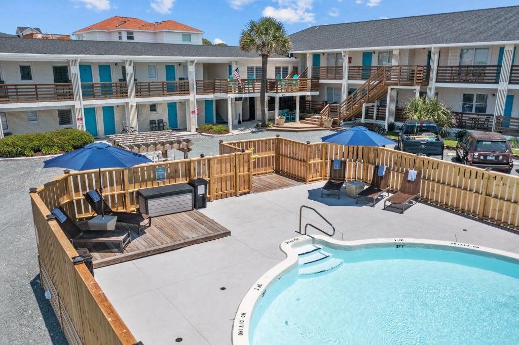 a swimming pool in front of a building with a resort at The Beach House at Oak Island by Carolina Resorts in Oak Island