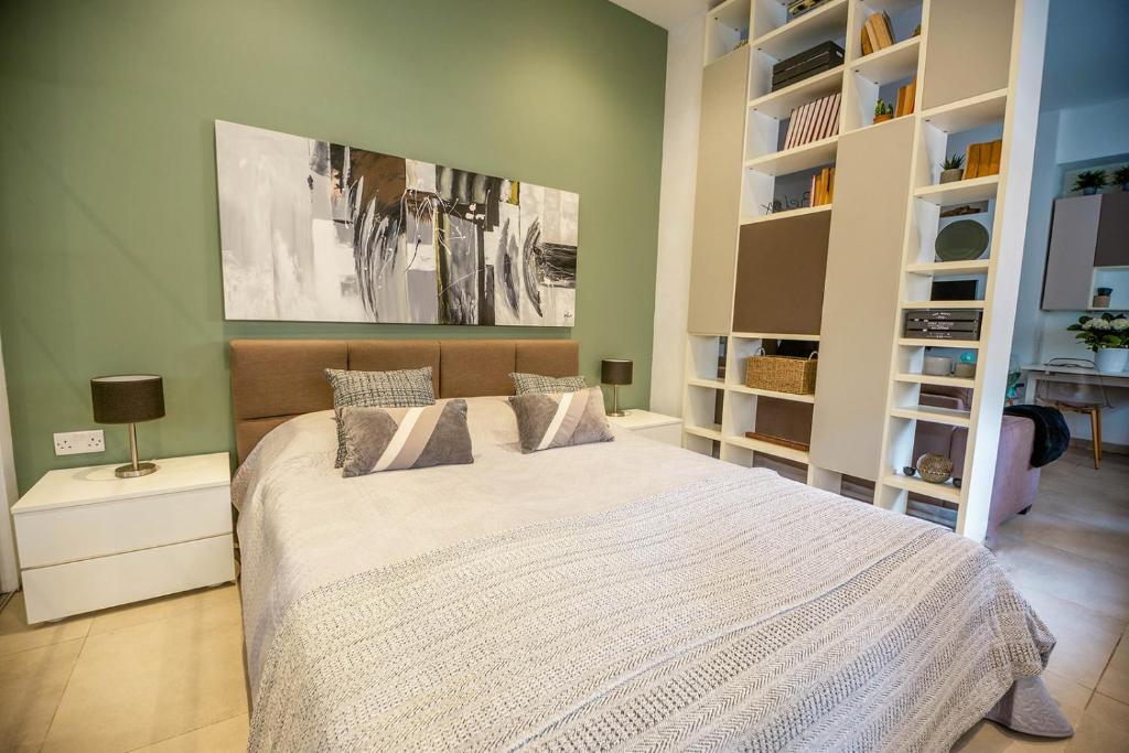 - une chambre avec un lit dans une pièce dotée d'étagères dans l'établissement Spacious studio apartment Sliema, à Sliema