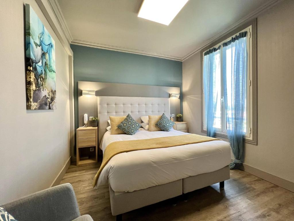 a bedroom with a large bed and a window at Hotel La Calanque in Mandelieu-La Napoule