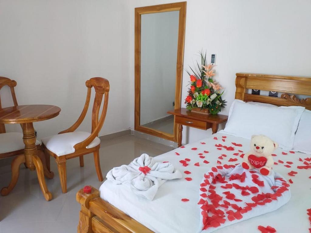 a bedroom with a bed with a teddy bear on it at CABAÑA MANANTIAL DE DIOS in Turbo