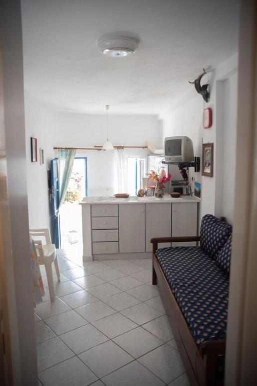 a kitchen with a couch and a table in a room at Michalis little sunrise in Mamádhos