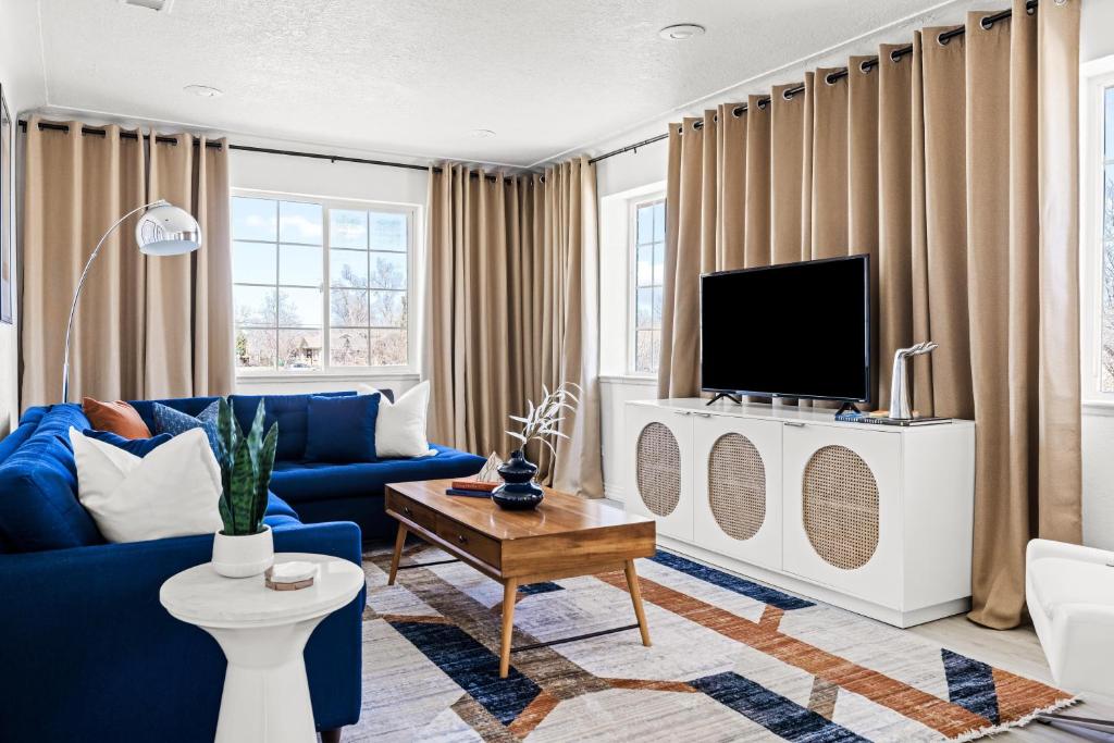 a living room with a blue couch and a tv at Bright & Modern Retreat - King Beds - Sloans Lake in Denver