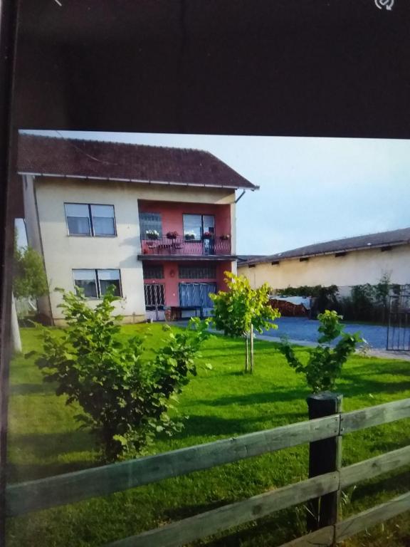 una casa con una recinzione di fronte a un cortile di Apartmani Primus a Bosanska Gradiška