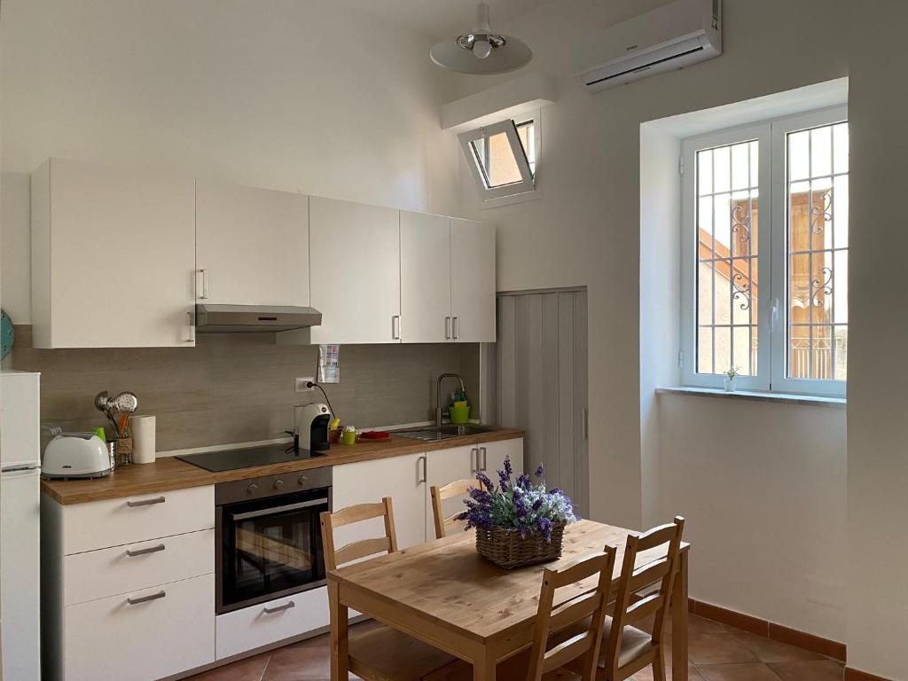 a kitchen with a table and chairs and a kitchen with white cabinets at Appartamento al civico 16 in Licata