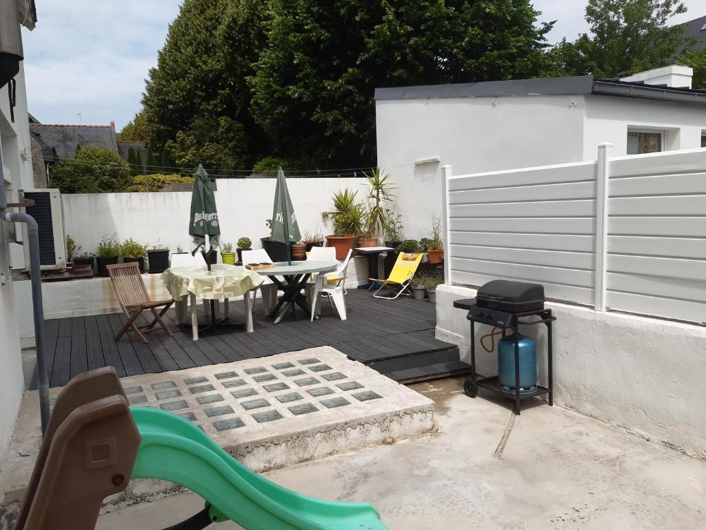 un patio avec une table, des chaises et un barbecue dans l'établissement spacieux T5 Quimper centre, à Quimper