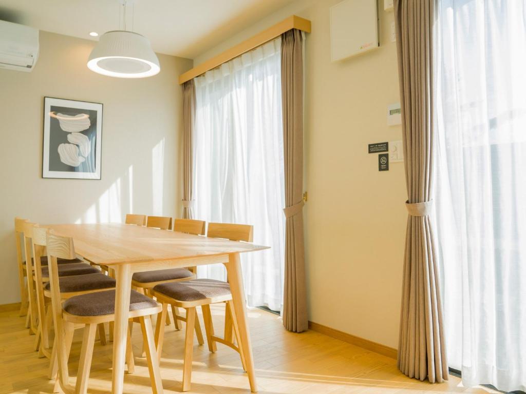 a dining room with a wooden table and chairs at Rakuten STAY VILLA Yatsugatake - 109 Simple Modern Pets Friendly - in Hokuto