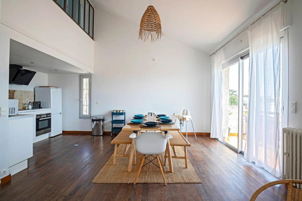une cuisine et une salle à manger avec une table et des chaises dans l'établissement Duplex Carnon, à Carnon-Plage
