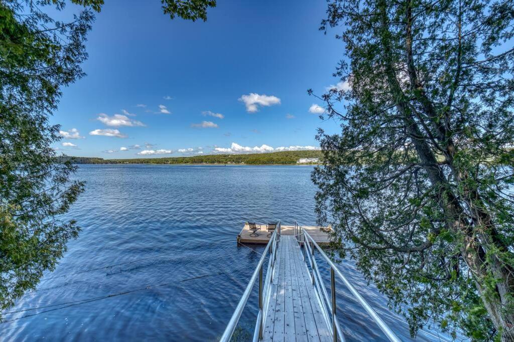 una barca su un lago con alberi in primo piano di Fabulous Waterfront Home Midcoast Maine 