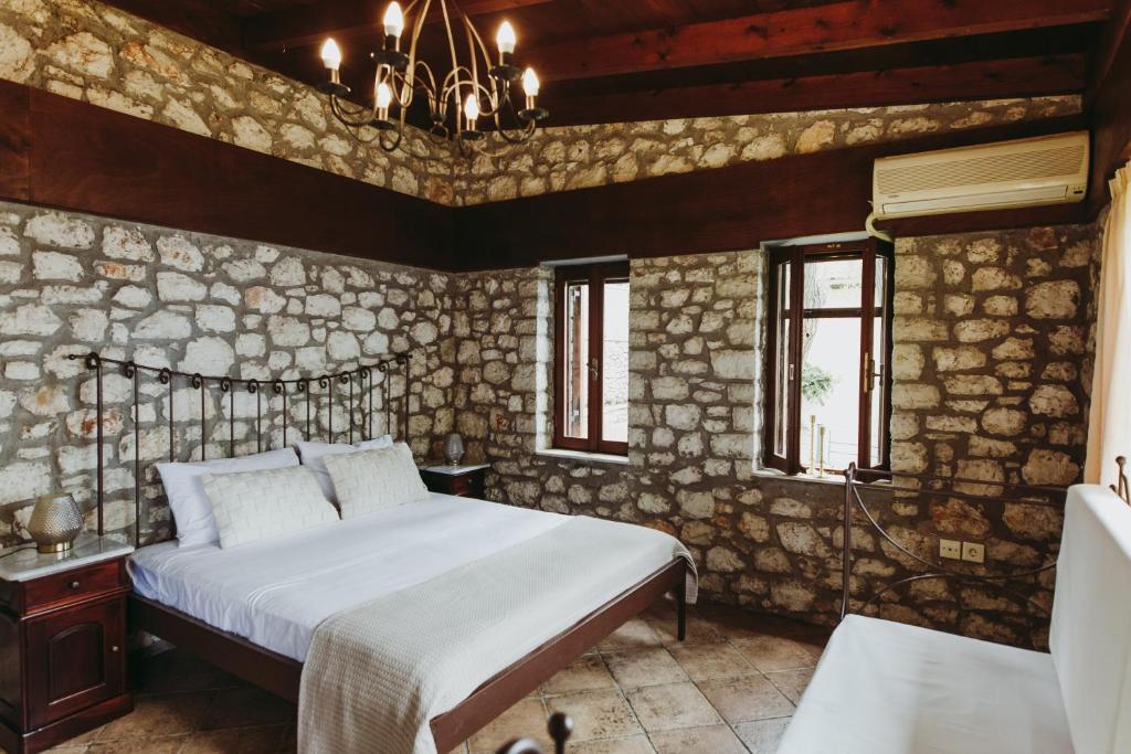 een slaapkamer met een bed en een stenen muur bij Carmel Villas in Drymon