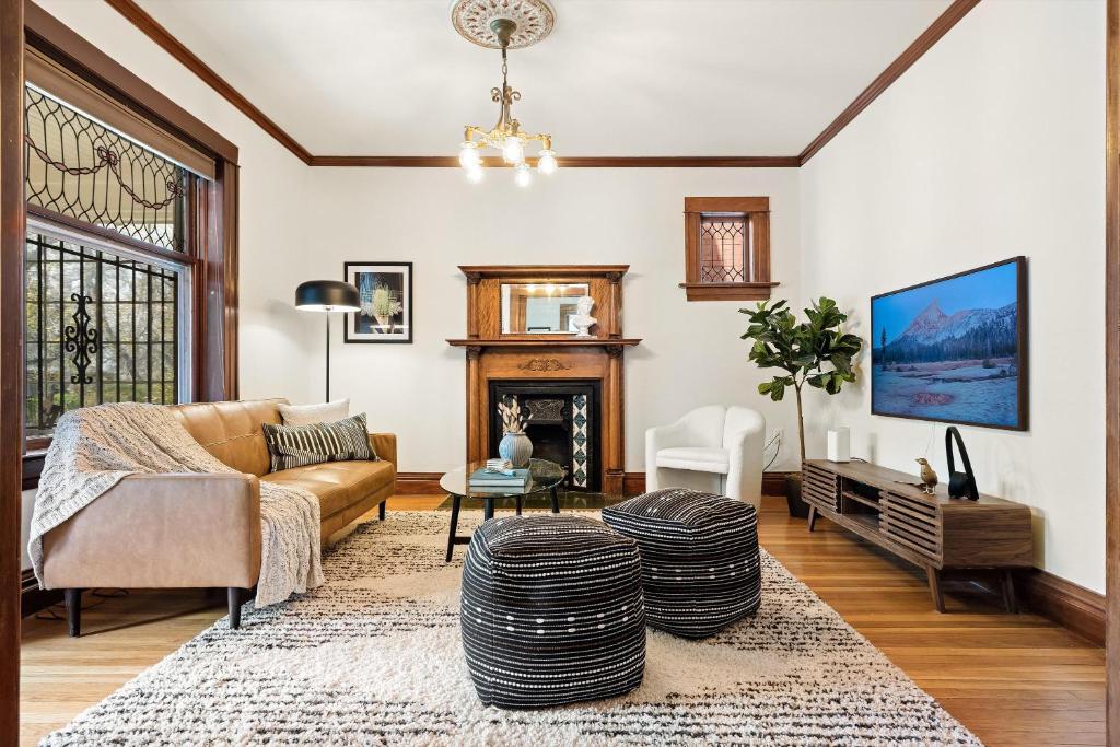 ein Wohnzimmer mit einem Sofa und einem Kamin in der Unterkunft Chic Victorian Manor - Sleeps 10 - Congress Park in Denver