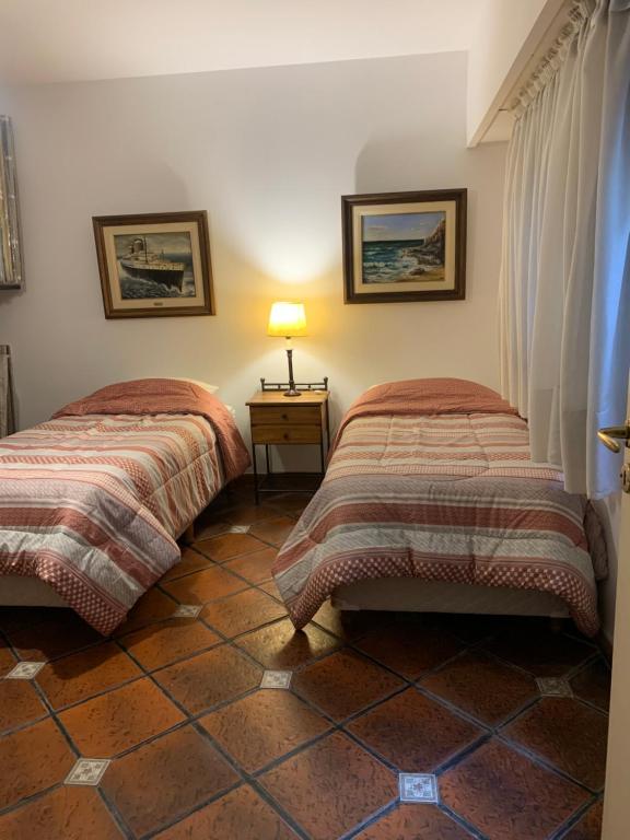 1 dormitorio con 2 camas y mesa con lámpara en El atelier en Vicente López