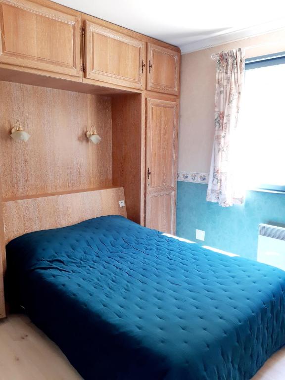 a bedroom with a blue bed and a window at Magnifique maison de campagne au cœur d&#39;un domaine viticole in Cazouls-lès-Béziers