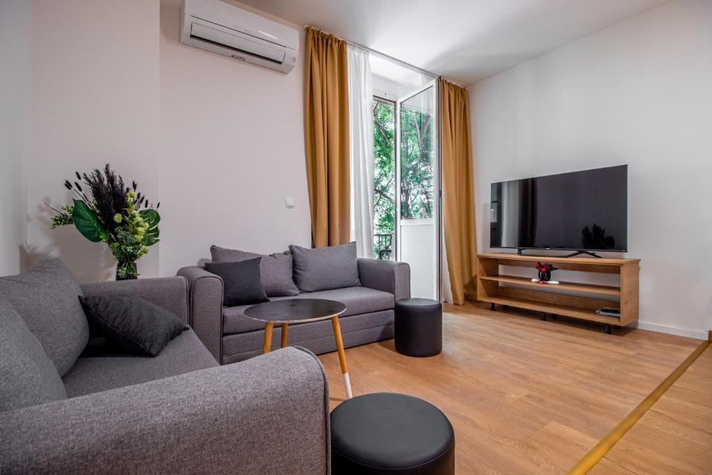 a living room with a couch and a tv at Apartments Euphoria East in Rijeka