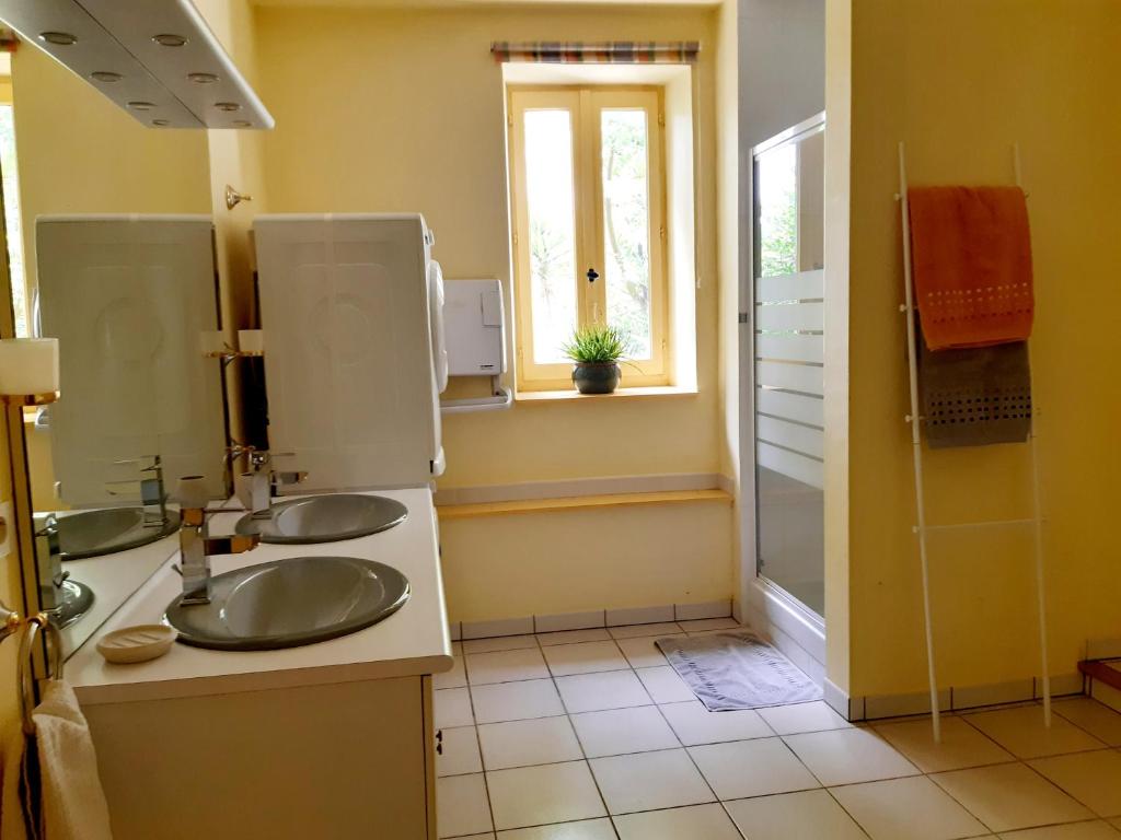 a bathroom with two sinks and a shower at Magnifique maison de campagne au cœur d&#39;un domaine viticole in Cazouls-lès-Béziers