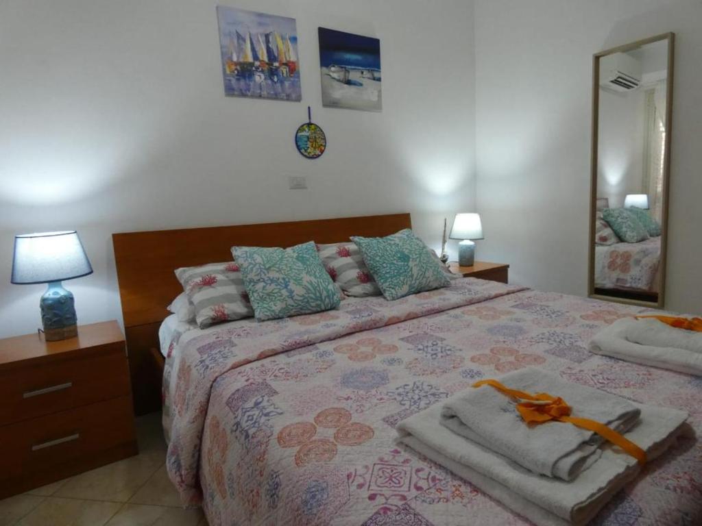 1 dormitorio con 1 cama grande y toallas. en Playa Bonita Relax House, en Scilla