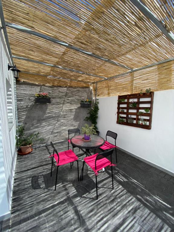 un patio con una mesa y sillas rosas en una terraza en Casa MIJAS PUEBLO La Villa Nueva en Mijas