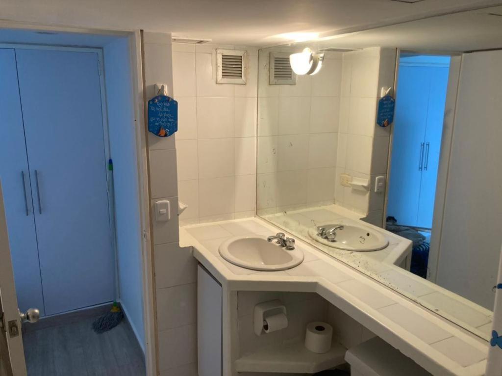 ein Bad mit einem Waschbecken und einem Spiegel in der Unterkunft Airport BleuSuite Apartment in Catia La Mar