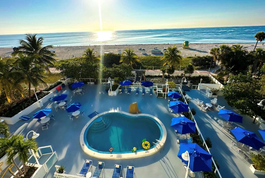 una vista aérea de una piscina con sillas y sombrillas en Best Western Plus Atlantic Beach Resort, en Miami Beach