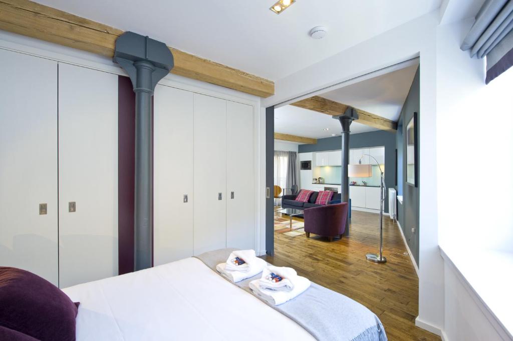 1 dormitorio con cama y espejo en Destiny Scotland -The Malt House Apartments, en Edimburgo
