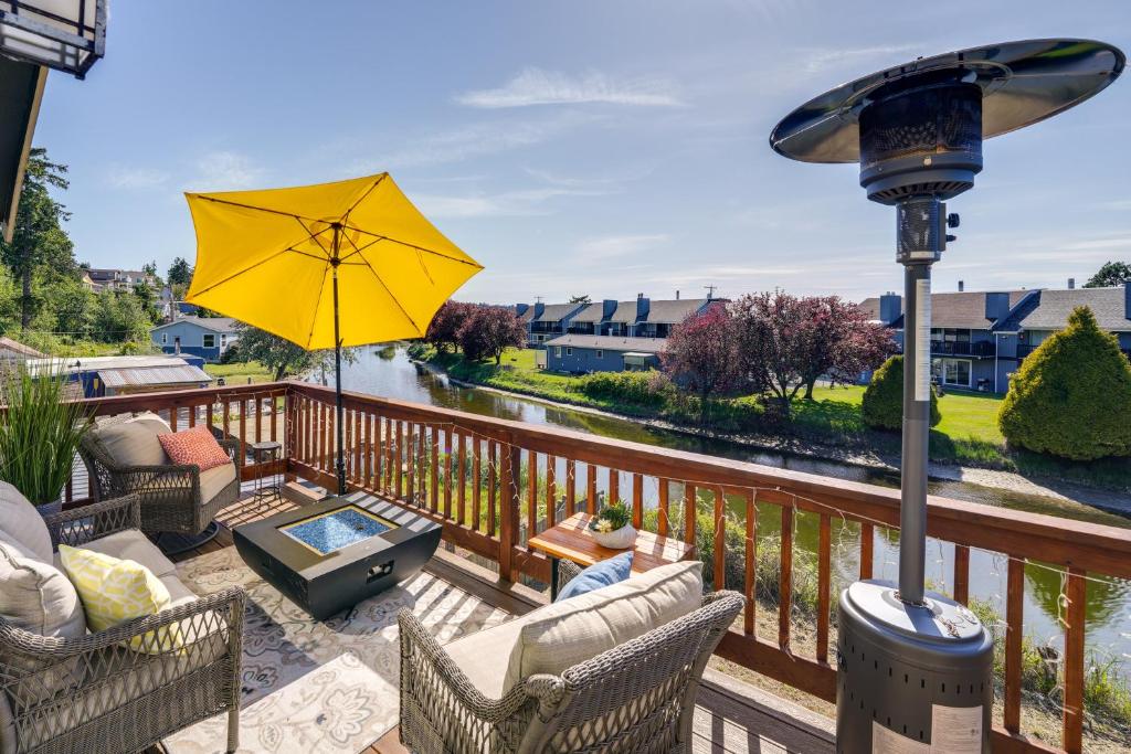 a patio with chairs and an umbrella on a balcony at Waterfront Birch Bay Rental - Walk to Beach! in Blaine
