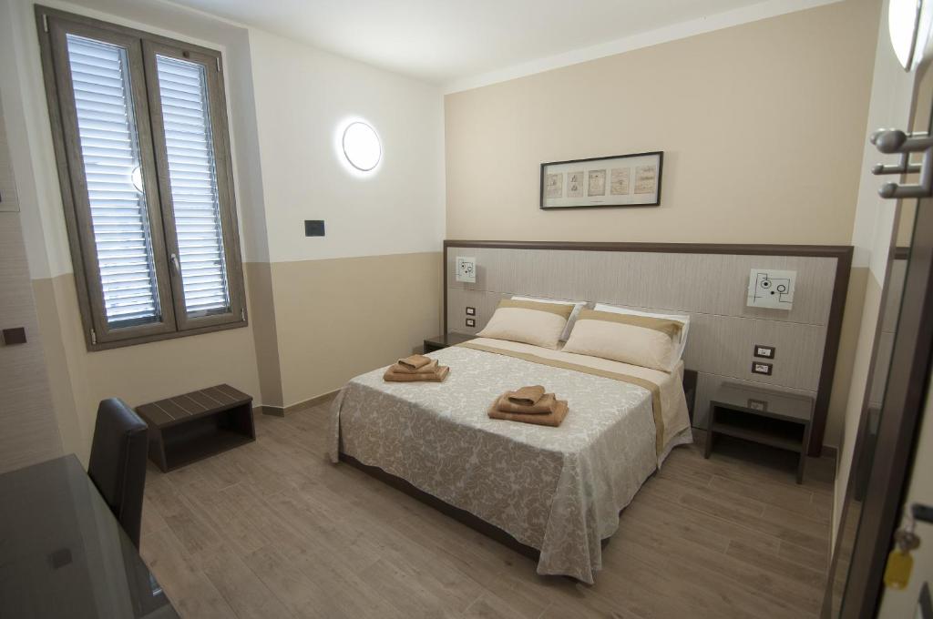 1 dormitorio con 1 cama con 2 toallas en Guesthouse Buonarroti Florence, en Florencia