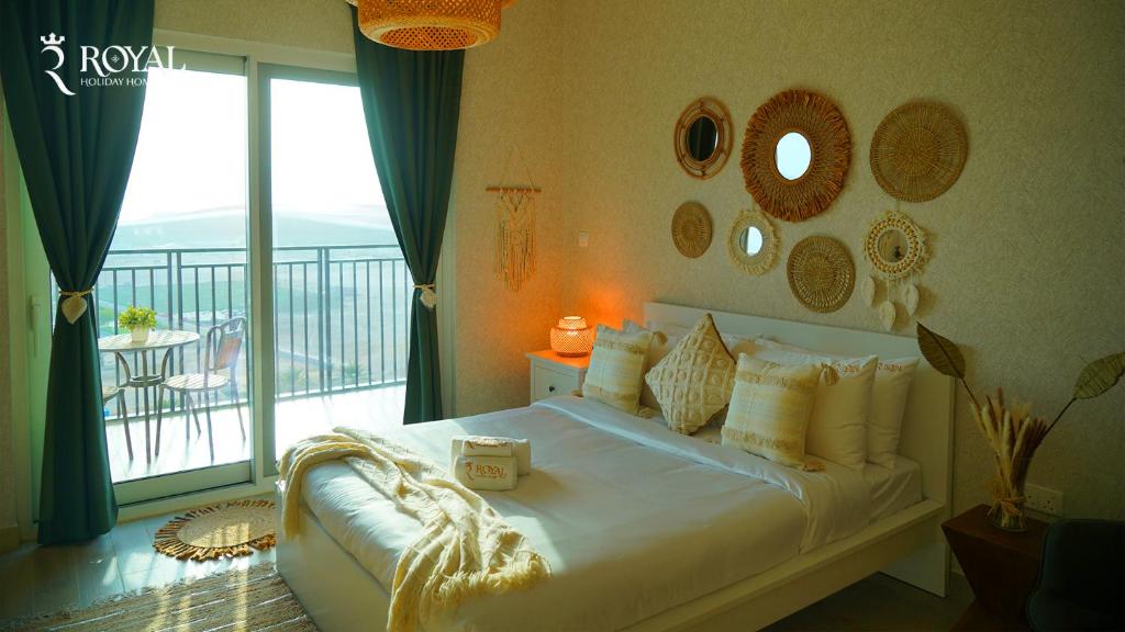a bedroom with a large bed with a balcony at Boho Chic Studio Apartment on Yas with Pool Access in Abu Dhabi