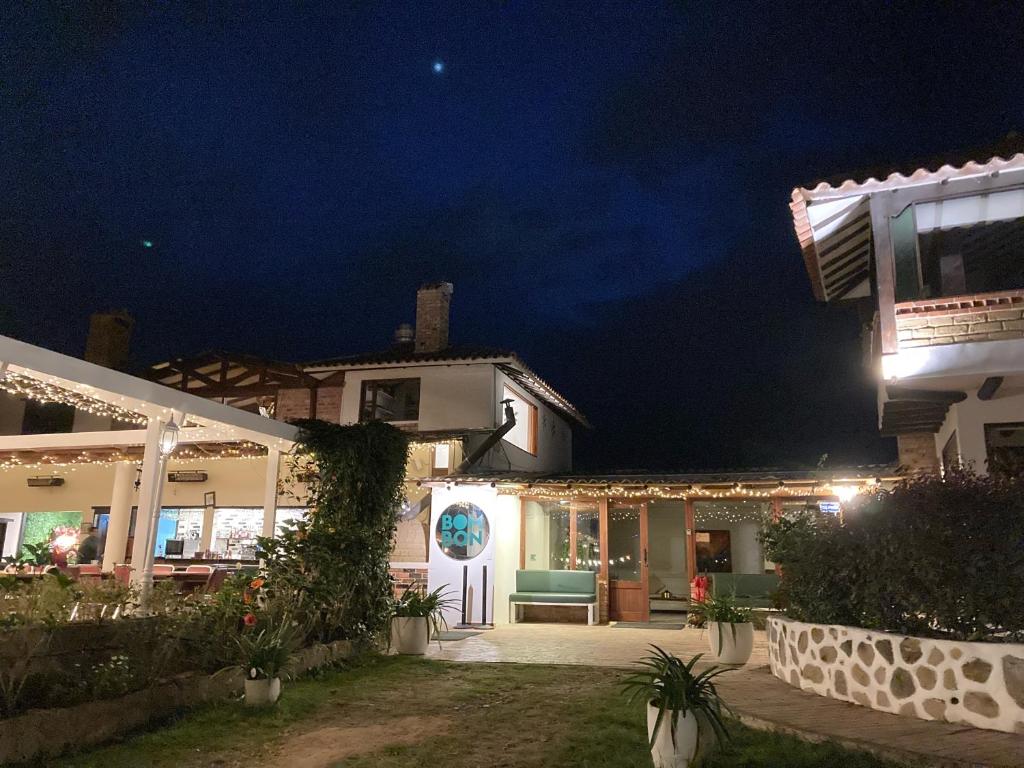 Una casa de noche con la luna en el cielo en Bombon Hotel, en Villa de Leyva