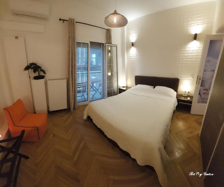 a bedroom with a white bed and an orange chair at Athens Riviera apt with seaview, 15' to Acropolis in Athens