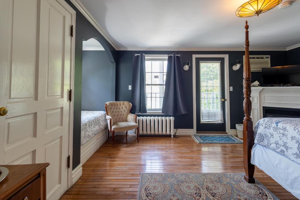 a bedroom with blue walls and a bed and a chair at Chestnut Inn in Niagara Falls