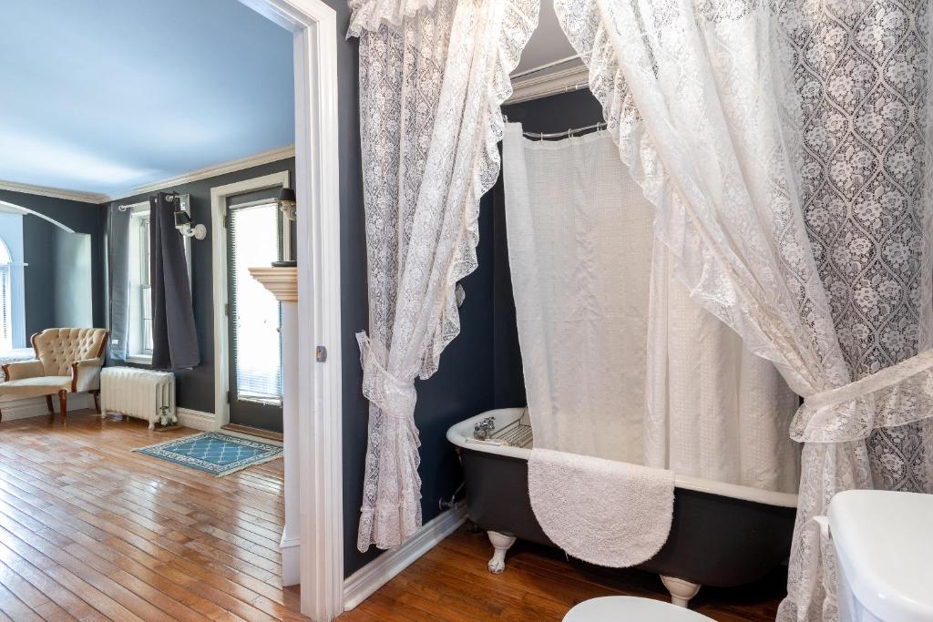 a bathroom with a bath tub and a window at Chestnut Inn in Niagara Falls