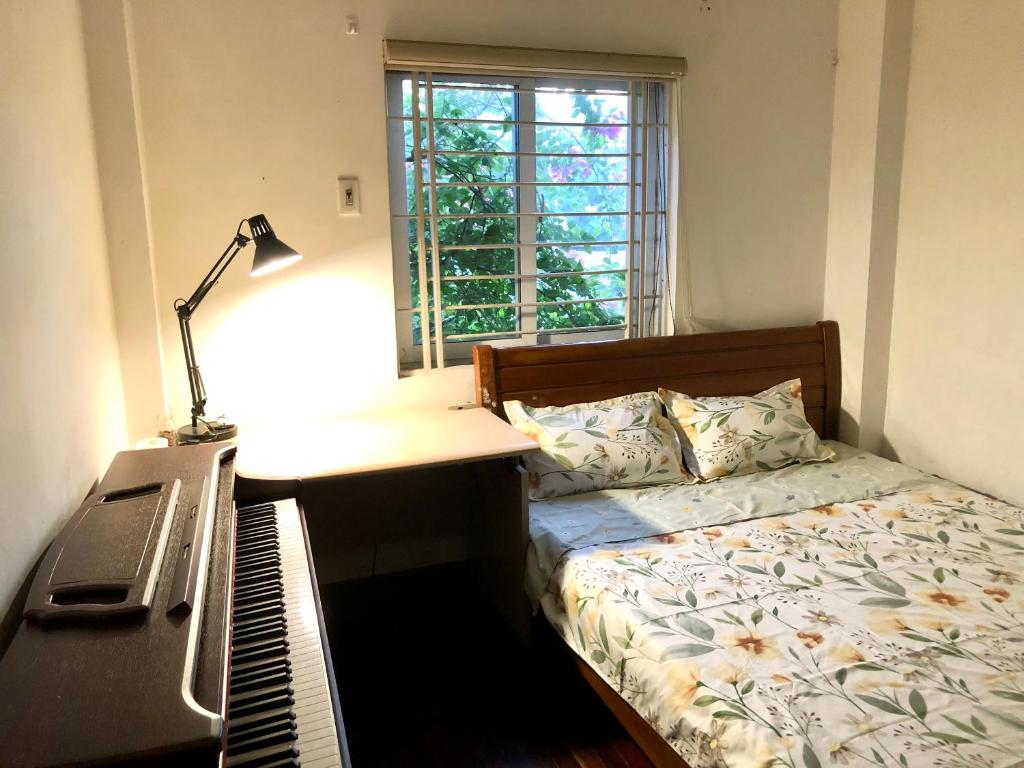 - une chambre avec un lit, un bureau et un clavier dans l'établissement Teachers House Hanoi Homestay, à Hanoï