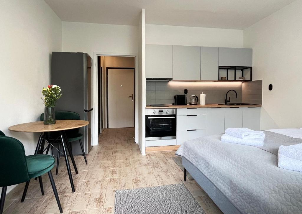 a room with a bed and a table and a kitchen at New cozy studio, private parking in Bratislava