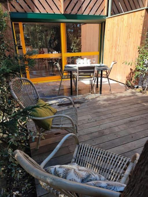 une terrasse avec deux chaises, une table et une table avec des chaises dans l'établissement Studio neuf au cœur de la presqu'île, à Lège-Cap-Ferret