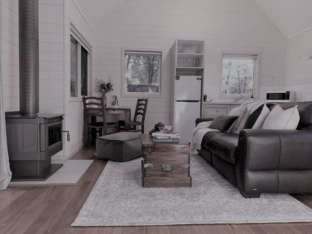 sala de estar con sofá y mesa en Two Truffles Cottage Accommodation, en Yarra Glen