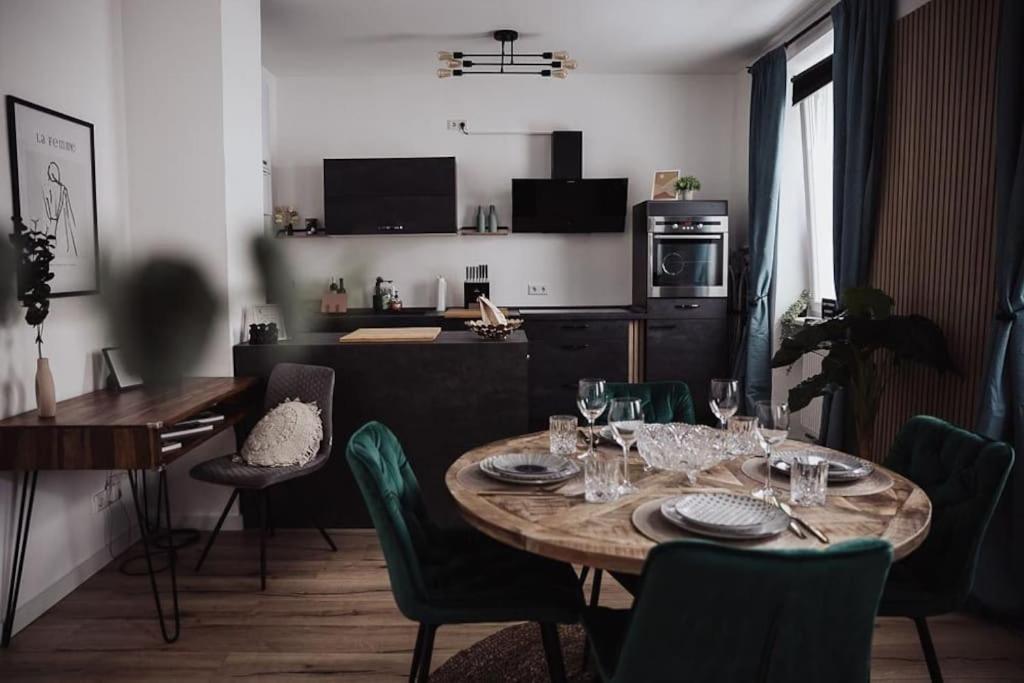 a dining room with a table and chairs and a kitchen at Cozy Dreams: Deluxe 2-Zimmer-Apartment -Küche in Nürnberg